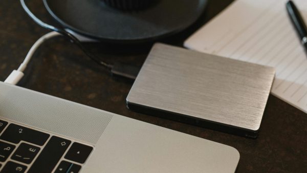 Secure Data Backup - Free Closeup of an external hard drive connected to a laptop with a USB cable on a desk. Stock Photo