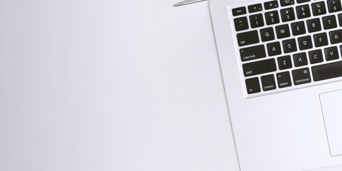 Device upgrade Free Aerial view of a sleek laptop keyboard on a clean, white surface, ideal for tech backgrounds. Stock Photo