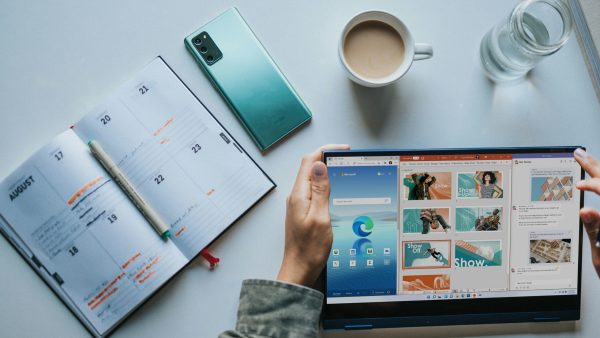 Microsoft 365 tips person using Windows 11 computer beside white ceramic mug on white table