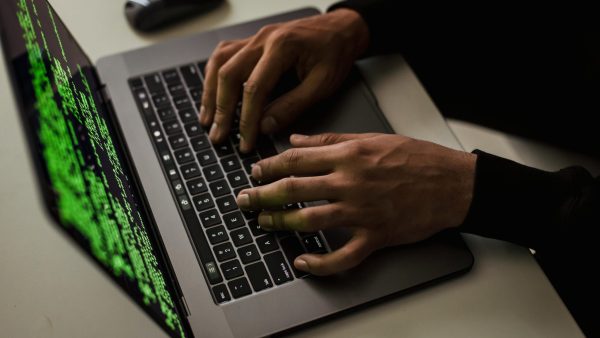 Account security crop-cyber-spy-hacking-system-while-typing-on-laptop