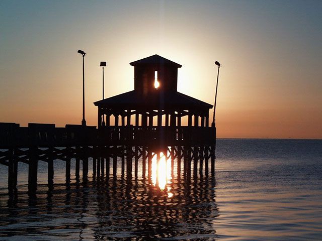 Silhouette of pier at sunset.