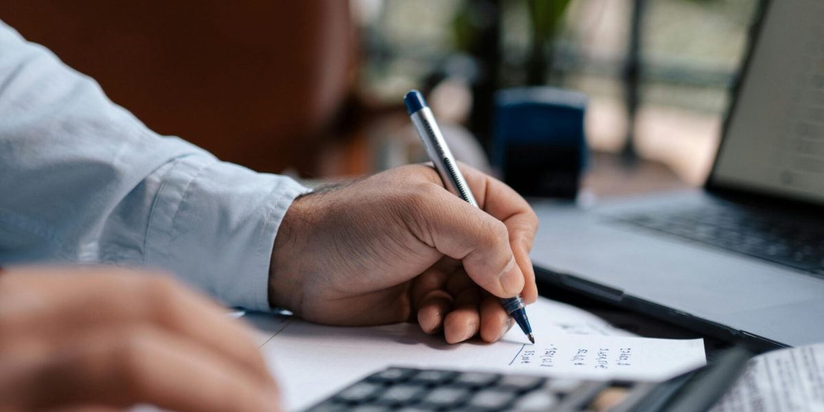 growth tech stack Free A person calculating finances with a calculator and pen on a desk indoors. Stock Photo