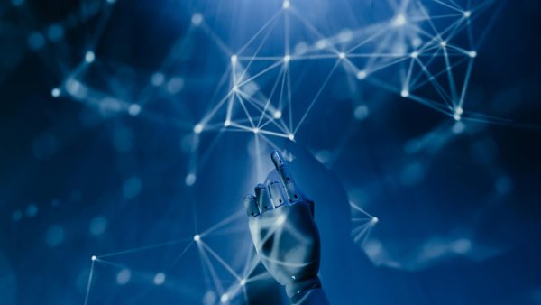 AI tools in 2025. Free A robotic hand reaching into a digital network on a blue background, symbolizing AI technology. Stock Photo
