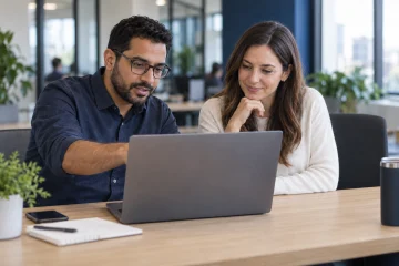 Two colleagues collaborating at one laptop